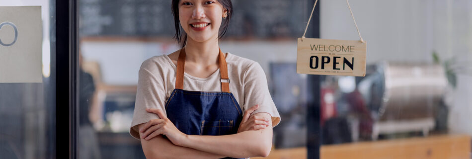 A small business owner using a PayPal card reader to process a payment from a customer in a cozy, well-lit retail shop. The image highlights the convenience and ease of mobile payments with PayPal Here, showing the card reader connected to a smartphone. The background features neatly arranged products on shelves, creating a welcoming shopping environment. This image emphasizes PayPal's role in supporting small businesses with efficient payment solutions.