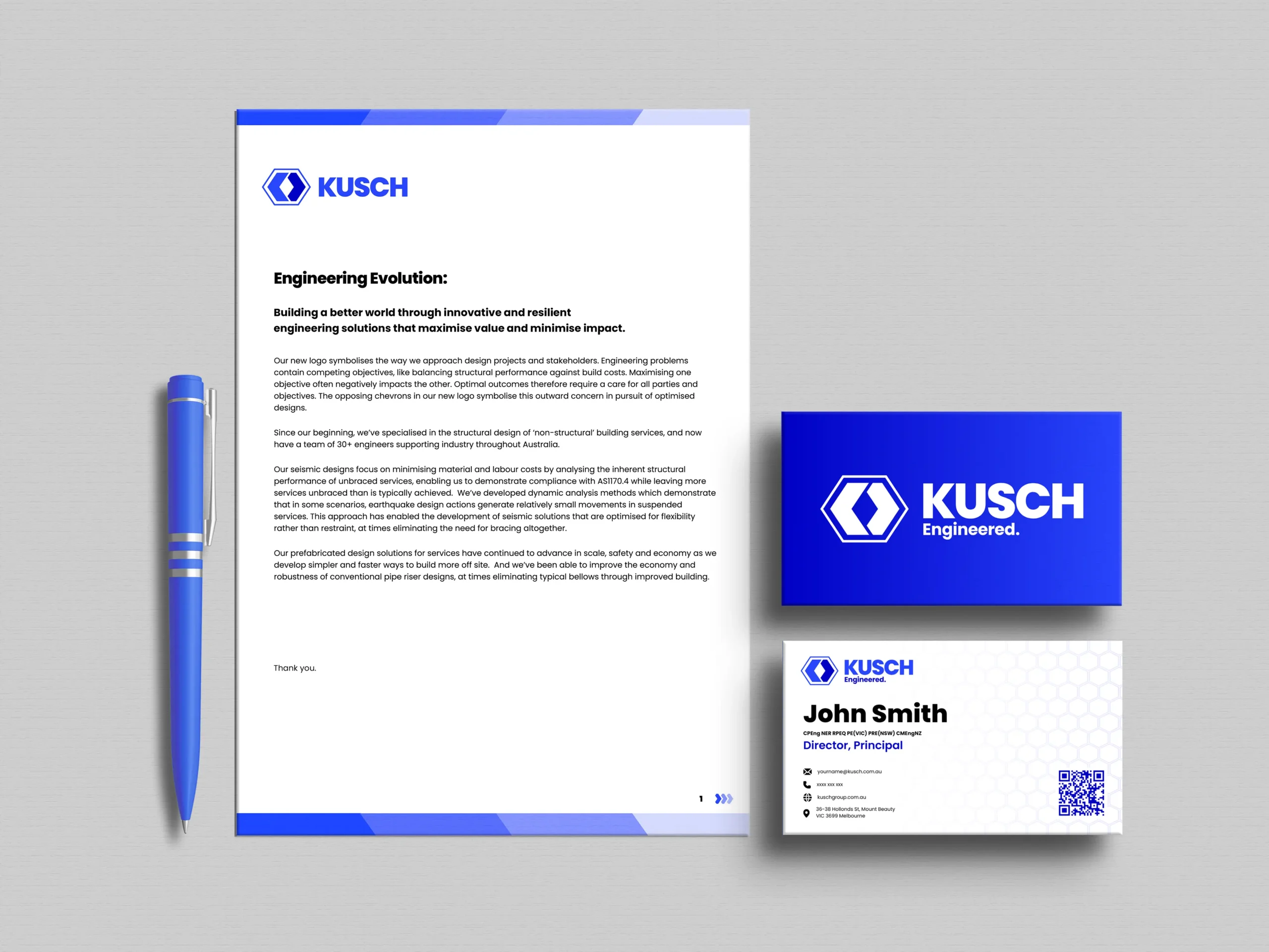 A mockup of Kusch branded stationery items arranged neatly on a wooden surface. The set includes a closed notebook with the Kusch logo prominently displayed, a business card with contact details, an envelope, a letterhead, and a pen. The design features a minimalist aesthetic with a clean, modern font and a monochromatic color scheme. The overall presentation highlights professionalism and cohesive branding for Kusch.